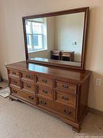 Front view of dresser with mirror attached showing overall appearance and drawer configuration