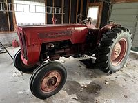 Full side view of red International tractor in garage