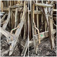 Two older wooden sleigh frames, resting in a barn or shed, showing metal brackets and fittings attached. The frames are weathered with some discoloration and signs of aging.