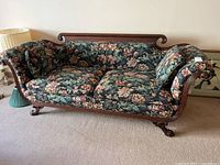 Sofa facing left showing floral upholstery, solid wood frame, and carved claw feet