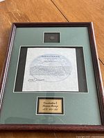 Full view of wood frame containing bronze coin, certificate and nameplate