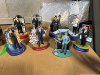 Photo showing all eight Frank Sinatra figurine music boxes grouped together on a gray surface.