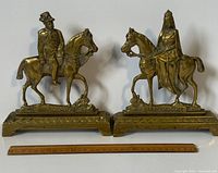 Front view of two solid brass equestrian doorstops with ruler for scale