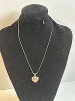 Full view of the necklace displayed on a black mannequin, showing chain length and heart pendant style.