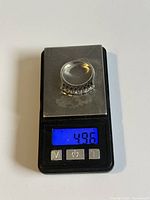 Ring placed on digital scale showing weight of 4.96 grams.
