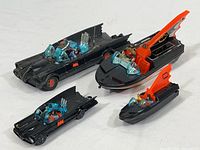 Four items arranged: two Batmobiles and two Batboats