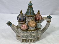 Front and left side view showing colorful onion dome spout and detailed architecture on ceramic tea pot shaped as St. Basil's Cathedral.
