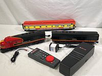 Overview of two Santa Fe F3 locomotives, Ringling Bros passenger car, Lionel controller, adapter, and base station