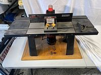 Full view of the Craftsman deluxe router table with mounted router, showing table surface and controls.