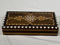 Top view showing detailed geometric wood inlay pattern with cream and brown tones on the lid.