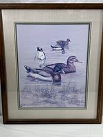Full view of the framed art print showing five ducks in water with reeds and ripples, framed in a wood frame with double matting.