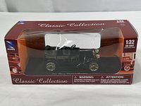 Image of the boxed 1:32 scale 1911 Chevy Classic Six Roadster model car by NewRay, showing the front and top of the box, model visible through transparent window.