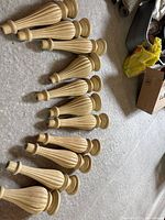 All eleven matching fluted wooden legs laid out on floor