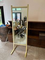 Front view of full-length mirror with cream frame and support legs