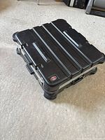 Closed case showing top surface, logo, handle recesses