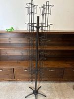 Full view of metal rotating wire display rack showing pockets, pole and base