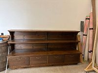 Front view of wooden shelving unit with open shelves and lower doors closed