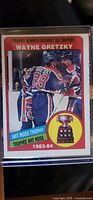 Front of 1983-84 OPC Wayne Gretzky #373 Art Ross Trophy hockey card showing Gretzky in Edmonton jersey with trophy information and Art Ross Trophy image.