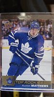 Front side of Auston Matthews rookie card in Toronto Maple Leafs uniform, showing player in action.
