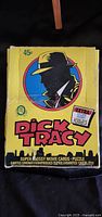 Box of 1991 Dick Tracy trading cards with stylized yellow packaging featuring Dick Tracy in silhouette on the front and text indicating 'Super Glossy Movie Cards' and extra puzzle pieces.