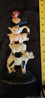 Front side showing the painted cast iron farm animals stacked vertically: rooster, goose, dog, sheep, pig, cow, with a black base, measured at about 8 inches tall.