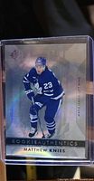 Front of the Matthew Knies rookie card showing the player in blue and white Toronto Maple Leafs uniform, card design with holographic elements, and text 'ROOKIE AUTHENTICS'.