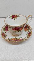 Porcelain teacup and saucer with detailed Old Country Roses floral design and gold trim.