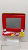 Ohio Art Etch A Sketch classic drawing toy in original red box with visible screen and knobs.