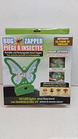 Front view of boxed rechargeable green butterfly-shaped bug zapper with UV LED lights and instructions on box in English and French.