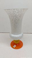 Full clear photo of the vase showing flared shape, speckled white upper body, yellow neck, and orange base.