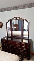 Front view of Almira wood dresser with attached mirror showing all drawers and mirror sections.