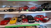 Wide shelf view showing 10 diecast collectible cars including two in acrylic display cases.