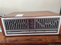 Front view of JVC SEA-70 graphic equalizer showing full front panel and wood veneer top.