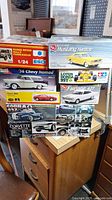 Photo showing boxed vintage model car kits including Ford Mustang, Range Rover Rally Paris-Dakar, Chevy Nomad, Corvette Indy Pace Car, Lotus Honda 99T, and Ferrari 348ts.