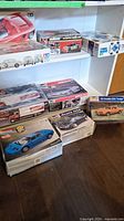 Shelf display with Volkswagen Beetle, Ferrari Mythos and other kits