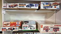 Mixed view of top and middle shelves showing six model kit boxes including Packard, Mercedes-Benz 600 SEL, Slammer Ford van, Lamborghini Miura, Castrol Skyline and Sd.Kfz.9/1