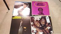Photo of four vinyl record albums: Michael Jackson Thriller, Stevie Wonder purple album cover, Dionne Warwick Greatest Hits of the 60's, Isaac Hayes To Be Continued album.
