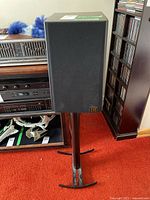 Front view of one speaker on its stand, cloth grille in place