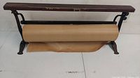 Front wide view of the antique butcher shop wrapping paper dispenser showing the roll of attached wrapping paper and wooden top shelf.
