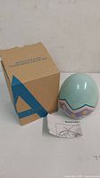 Avon Musical Chick in Egg with original box and instruction sheet displayed on a white surface.