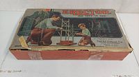 Closed vintage Erector set box with father and son illustration, showing damage and wear