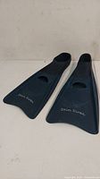 Pair of dark blue rubber swimming flippers with Skin Diver logo on blades and a rectangular cut-out near foot pocket
