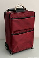 Front view of red Sub-O-G carry-on suitcase showing two zippered front pockets and top handle