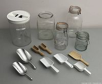 Photo of all items in lot including clear plastic container with white lid labeled 'pastry', three glass jars with clamp lids, one glass jar without lid, eight scoops of various sizes and materials.