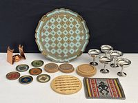 Copper brandy warming stand, wooden serving tray with 6 wooden coasters, wooden trivet, and a fabric coaster with geometric pattern, plus small coasters and matches.