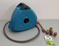 Blue GARDENA self winding hose reel with attached hose and extra connectors placed alongside.