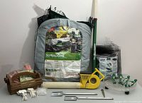 Overview of the lot showing garden duster, Superdome, wooden basket, plant clips, stakes, and netting