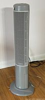 Tower fan showing front mesh grill and base