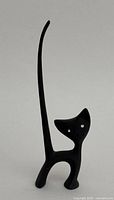 Full view of the black iron cat figurine showing its tall, slender tail and standing posture