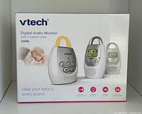 Box showing VTech Digital Audio Monitor with 2 parent units, highlighting features like two-way talk-back, vibrating sound-alert, nightlight on baby unit, 5-level sound indicator, and DECT 6.0 technology.